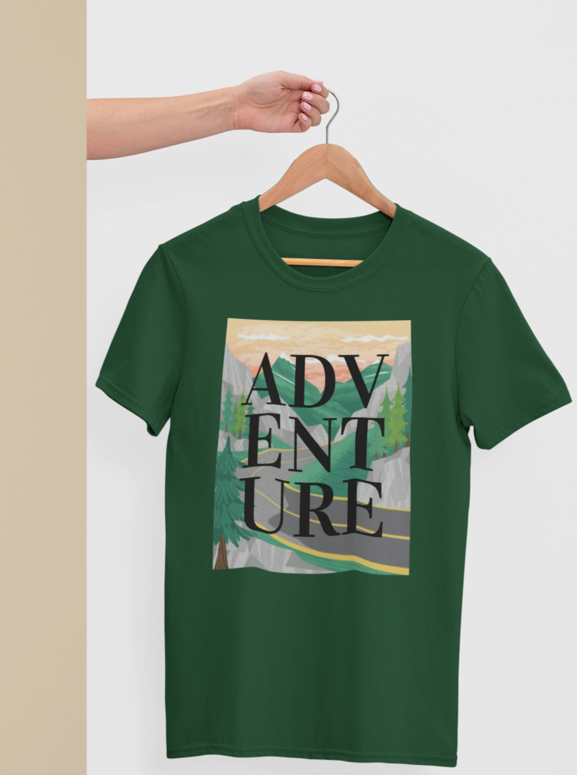 green tshirt with a design of mountains and a road with adventure written on it